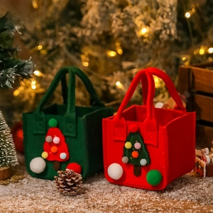 Detail of red and green Christmas felt gift bags with 3D tree and colorful pom poms