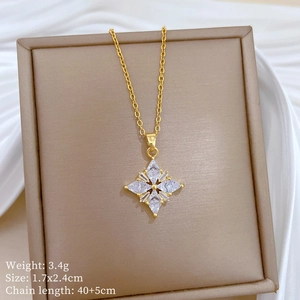Macro detail of a gold clover pendant with sparkling rhinestones on a jewelry tray