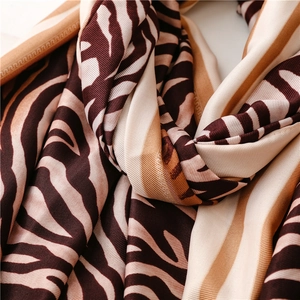 Close-up of zebra pattern silk scarf showing brown fabric texture and smooth sheen