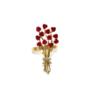 Detailed view of a gold napkin ring with a red rose and sparkling rhinestone bow detail