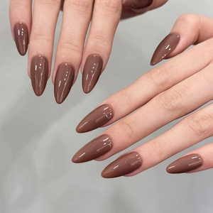 Unghie finte a mandorla marrone caramello lucido per una manicure dal tocco minimalista