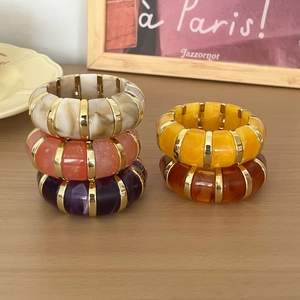 Gros plan de bracelets en résine marbrée avec intercalaires en métal doré multicolores