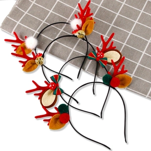 Detail view of Christmas antler headbands with red bows, golden bells and soft fur balls