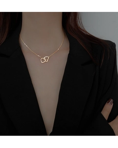 Close-up of elegant double interlocking heart necklace worn on female model's neck