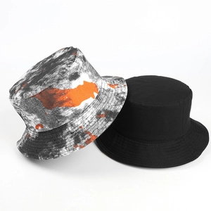 Detail of reversible tie-dye bucket hat with neon orange accents and black cotton fabric