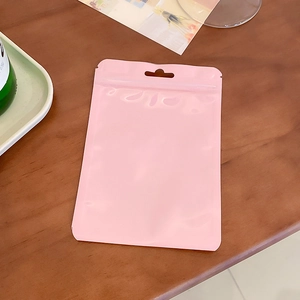 Detailed view of pink self-standing macaron color ziplock storage bag on a wooden table