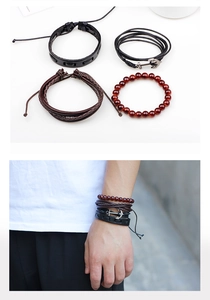 Macro view of four-piece vintage leather bracelet set with anchor charm for men