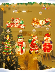 Close-up of a Santa Claus suction cup LED light with warm glowing Merry Christmas sign