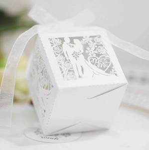 Close-up of laser-cut wedding candy box with Mr & Mrs silhouette and white ribbon