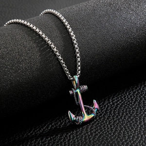 Detail shot of multicolor anchor pendant on silver box chain over black leather background