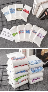 White crew socks featuring colorful graffiti embroidery displayed on a textured background