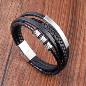 Detailed close-up of multi-layer black leather woven bracelet with silver metal charms
