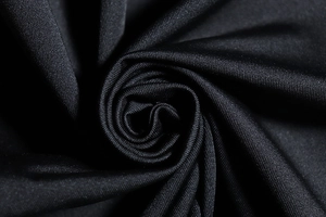 Macro shot of black high-elasticity knit fabric with smooth texture and subtle glossy finish
