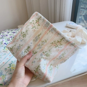 Close-up of floral print cotton makeup bag with Simple Wish label in soft lighting