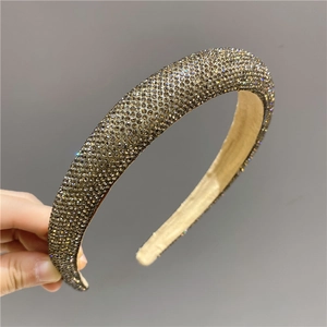 Detailed macro shot of premium champagne gold rhinestones on a wide-edge headband