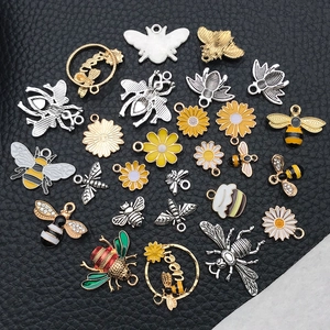 Macro shot of assorted bee and daisy alloy charms with enamel and rhinestone details