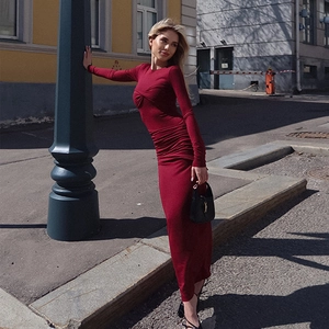 Détail d'une robe rouge à manches longues avec nœud élégant et coupe ajustée froncée