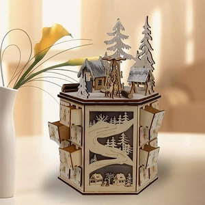 Detail of laser-cut wooden advent calendar with 24 small drawers and winter village scene