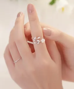 Detail of adjustable S925 silver ring featuring crystal leaves and a small white flower