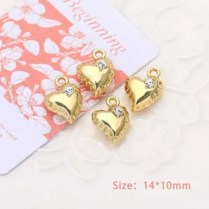 Macro view of gold heart pendants with rhinestones and scalloped edges, 14x10mm size
