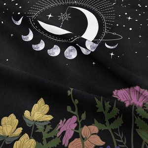 Detail of moon phase astrology print and vibrant floral patterns on black fabric tapestry