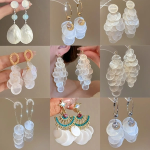 Collage de boucles d'oreilles en nacre avec détails dorés et perles colorées variées