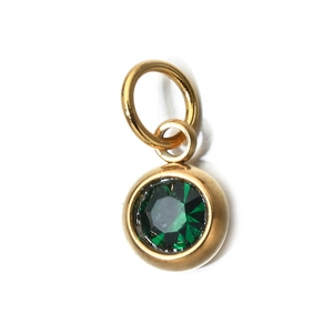 Macro shot of a 6mm green birthstone pendant with golden stainless steel bezel setting
