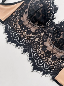 Close-up of black eyelash lace bra with floral embroidery and sheer nude lining