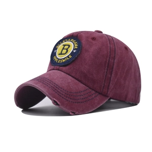 Detail of burgundy baseball cap with B letter embroidery and distressed brim edge