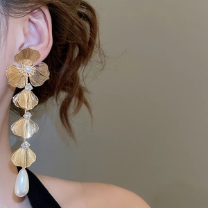 Detail of 18K gold plated tassel earrings with crystals and white teardrop pearls on model
