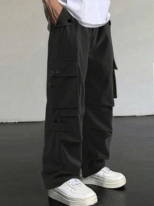 Side view detail of black baggy cargo pants featuring tactical multi-pocket design