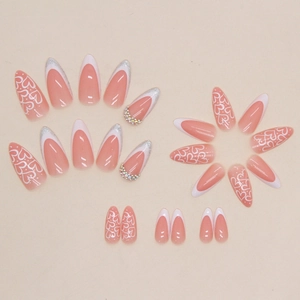 Pink almond press-on nails with white French tips, glitter accents, heart patterns, and gems