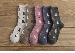 Flat lay of five pairs of wool blend mid-calf socks with cat and heart patterns
