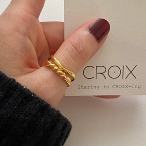 Detailed close-up of a double-layer gold knot ring with twisted texture and smooth band