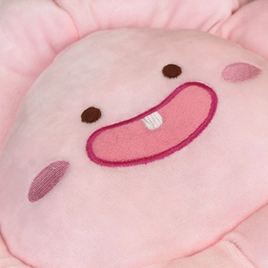 Gros plan d'un coussin fleur rose en peluche avec broderie faciale mignonne