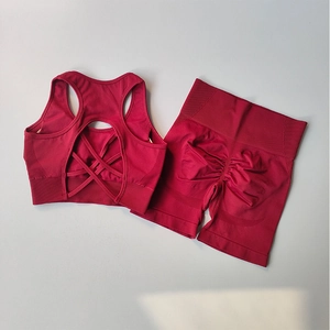Flachgelegtes nahtloses tiefrotes Sport-BH-Set mit überkreuztem Rücken und Yoga-Shorts