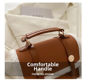 Detail of a brown leather and white faux shearling handbag with gold metal clasp