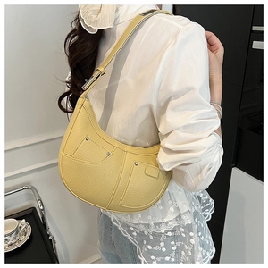 Detail of yellow crescent shoulder bag with lychee texture and rivet pockets