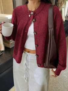 Détail du cardigan en maille bordeaux avec col rond et grands boutons foncés sur mannequin