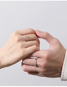 Detail showing hands of a couple wearing S925 silver twist rings with a single diamond