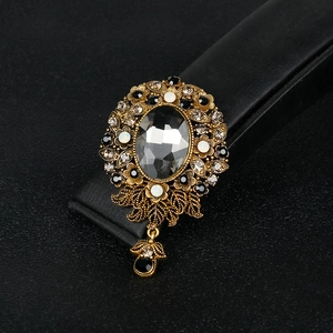 Vintage rhinestone alloy brooch with a dark oval gem and glass pendant on black leather
