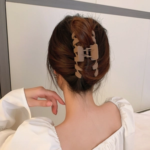 Vue arrière d'une pince à cheveux géométrique marron mat pour un chignon élégant