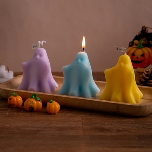 Ghost-shaped scented candles in purple, blue, and yellow for Halloween home decoration