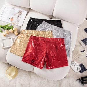 Hoch taillierte Pailletten-Shorts in Rot, Gold, Silber und Schwarz auf weißem Sofa