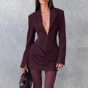 Dettaglio dell'abito blazer bordeaux con chiusura a ganci metallici e orlo a pieghe