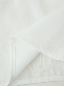 Detailed macro view of white linen-cotton blend fabric texture and fine stitched seams