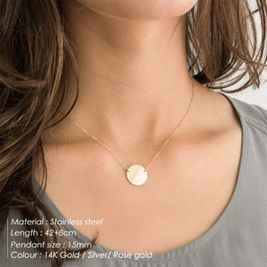 Polished stainless steel round pendant necklace on model with 14K gold finish