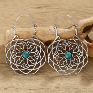 Macro view of silver bohemian flower of life earrings with turquoise stone inlays