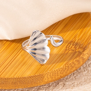 Detailed close-up of an adjustable ginkgo leaf ring in stainless steel on wood