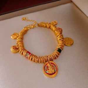Macro shot of gold-plated bracelet with Fu character and lucky charms on satin